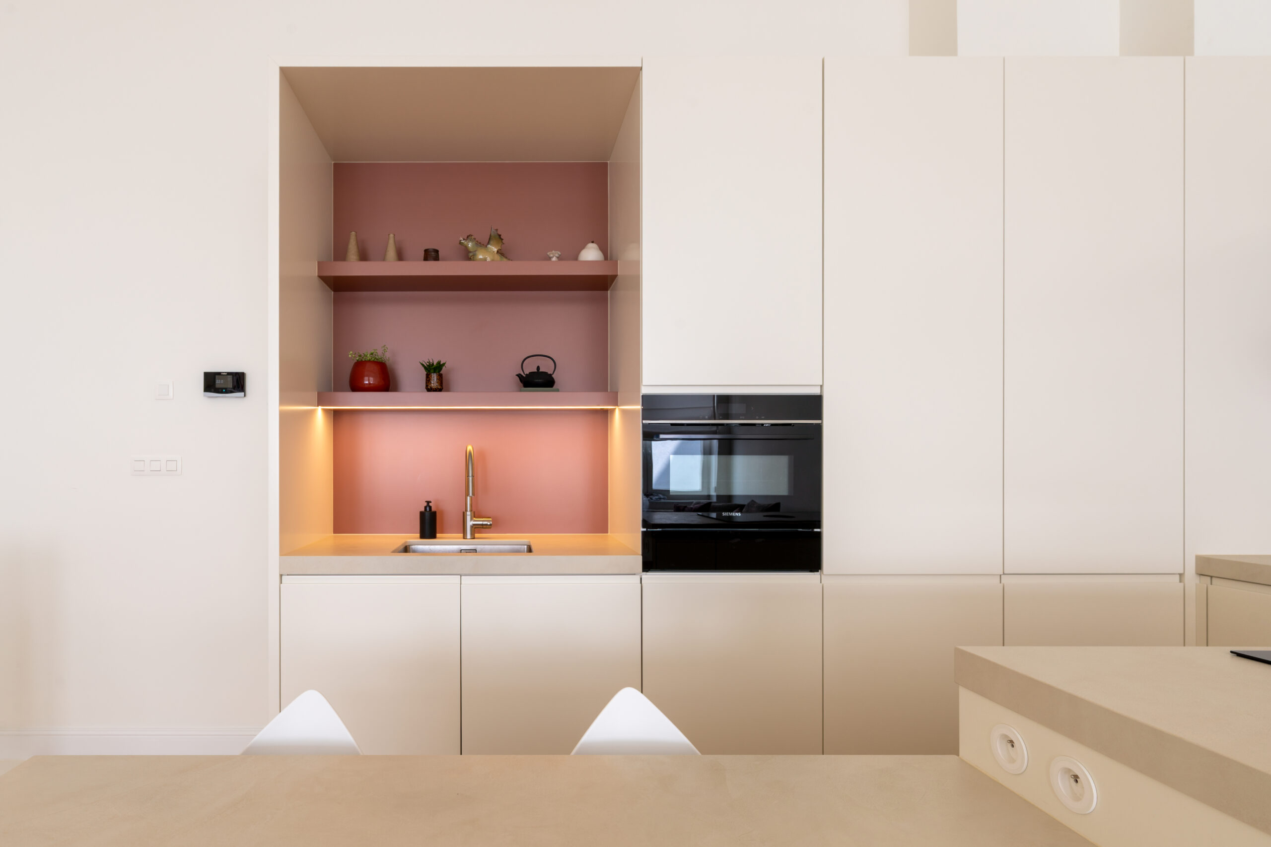 witte moderne keuken met een nis in roze accenten
