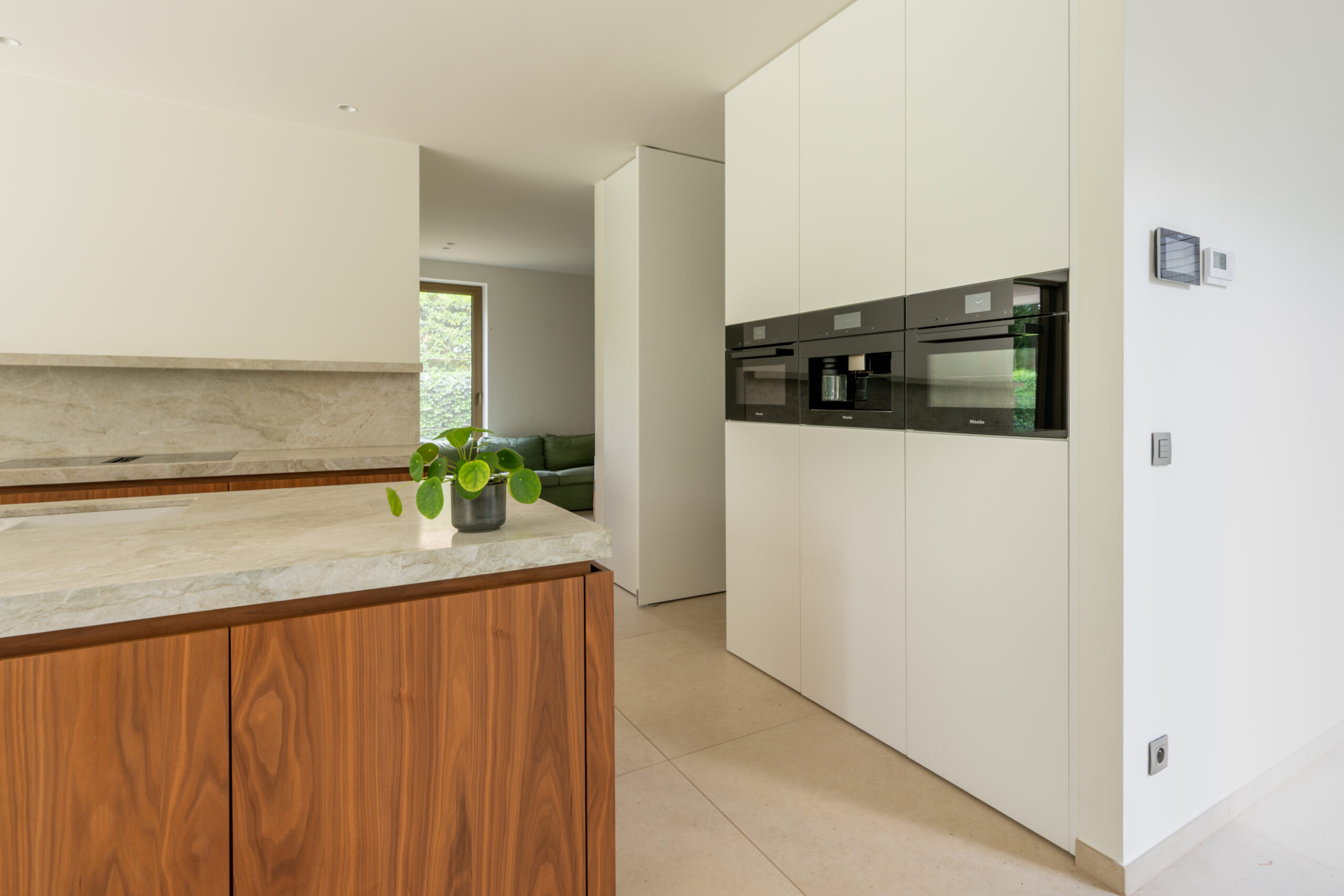 minimalistische keuken met natuurlijke materialen en witte kastenmuur
