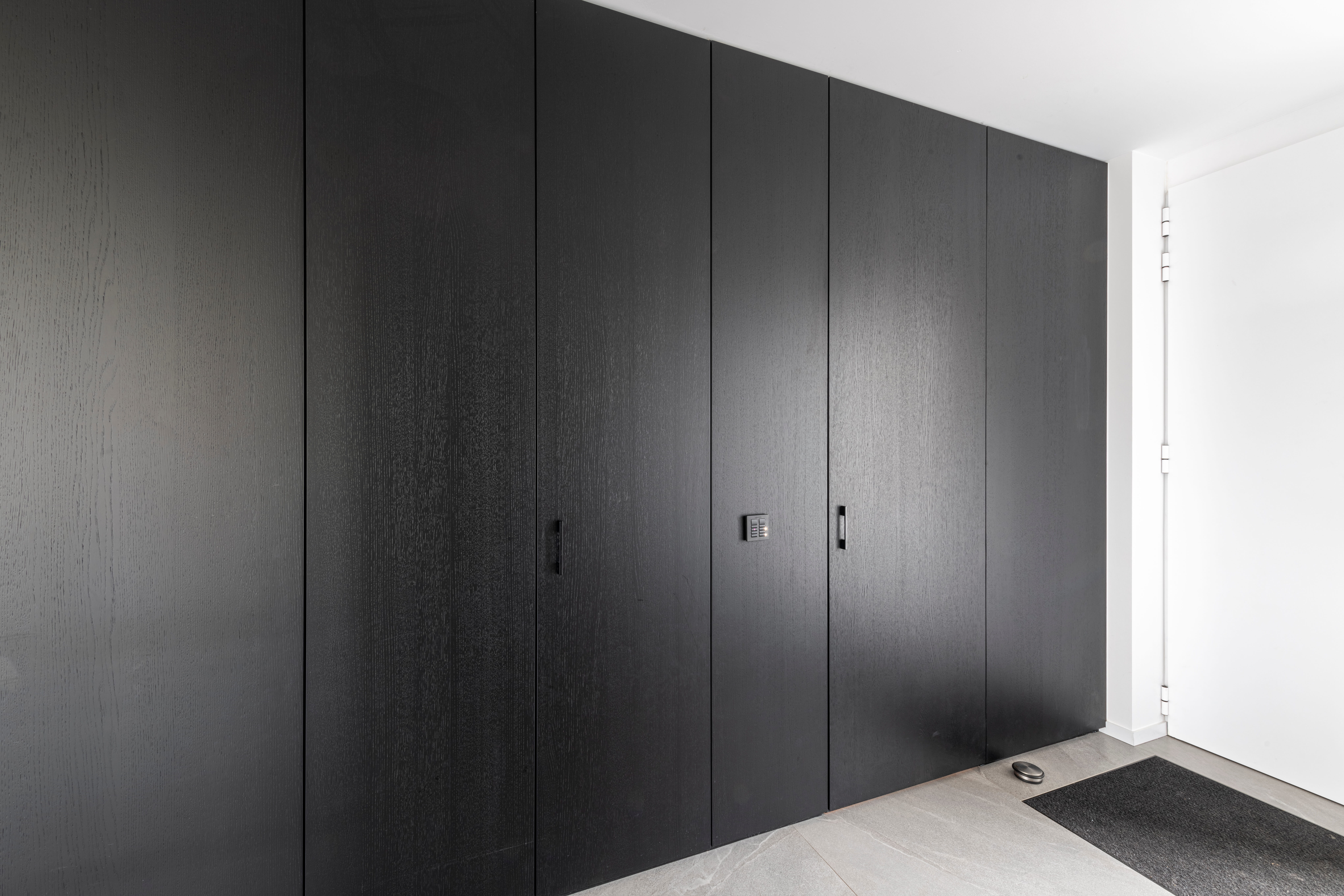vestiairekast op maat in zwart hout met ingebouwde deur naar toilet